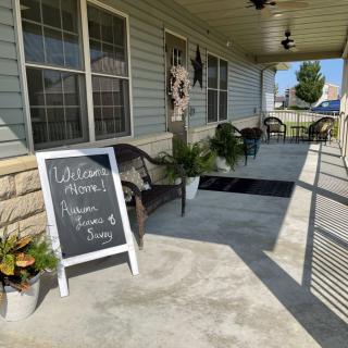 A welcoming porch with a chalkboard sign and cozy seating area.