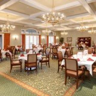 An elegant dining room with neatly arranged tables and chandeliers.