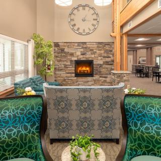 A cozy living room with a central fireplace, stylish furniture, and decorative elements.