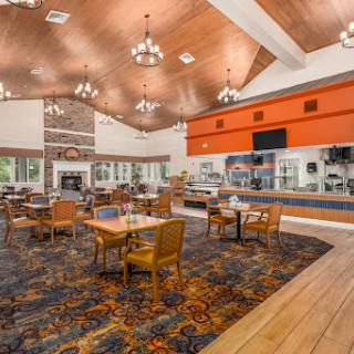 A cozy dining area with wooden accents and a vibrant carpet, perfect for enjoying meals.