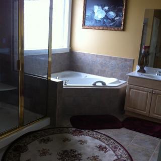A modern bathroom with a corner bathtub, separate shower, and elegant decor.