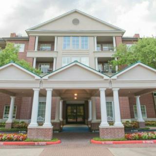 A grand residential building with a columned entrance and well-maintained landscaping.