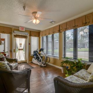 A cozy living room with exercise equipment, large windows, and comfortable seating.