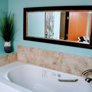 A modern bathroom featuring a bathtub with a tiled wall and elegant decor.