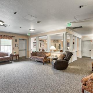 A cozy living room with sofas, chairs, and large windows.