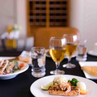 A gourmet meal featuring seafood and white wine served elegantly at a restaurant.