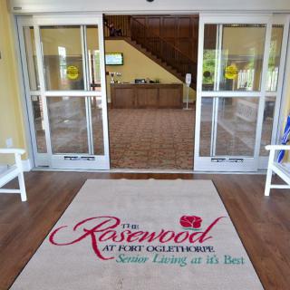 Entrance to a senior living facility with a welcoming mat.