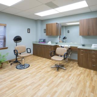 A well-lit interior of a hair salon featuring stylist chairs and a vanity area.
