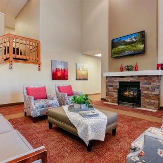 A cozy living room featuring a fireplace, comfortable seating, and decorative artwork.