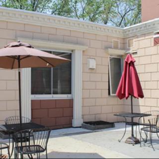 A sunny outdoor patio with tables and umbrellas.