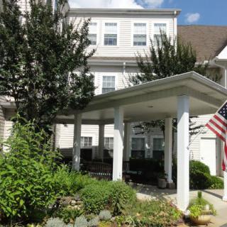 A residential building with a garden and American flag displayed.