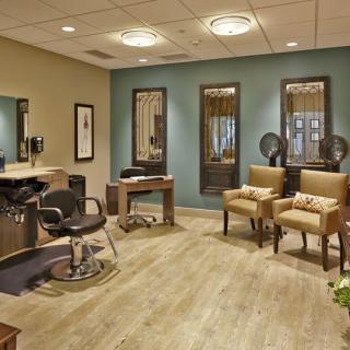 A modern hair salon interior with stylish chairs, mirrors, and a hairdressing station.