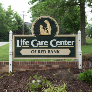 Sign for Life Care Center of Red Bank located outdoors amidst greenery.