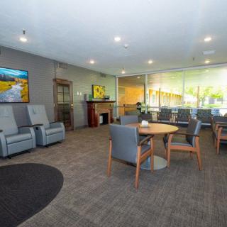 A modern and comfortable waiting room with several chairs and tables.