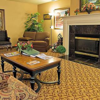A cozy living room with a sofa and coffee table in front of a fireplace.