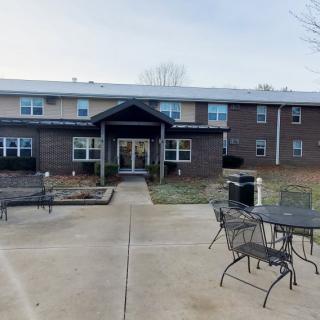 A two-story building with a front entrance and outdoor patio furniture.