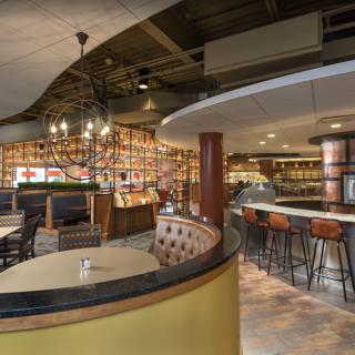 A stylish restaurant interior featuring a modern bar and cozy seating areas.