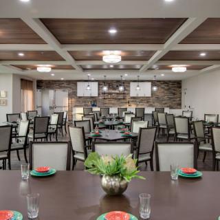 A spacious and elegantly designed dining or meeting area with neatly arranged tables and chairs.