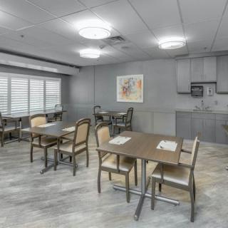 A modern dining area with multiple tables and chairs, featuring soft lighting and contemporary interior design.