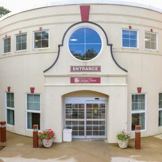 The entrance of a modern architectural building with stylish windows and landscaping.
