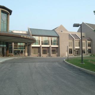 A view of a modern building with a welcoming entrance and driveway.