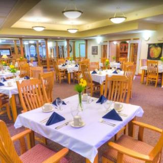 An elegant restaurant dining area with well-set tables and wooden chairs.