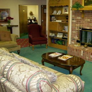 A cozy living room with a sofa, armchairs, and a brick fireplace.
