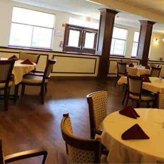 An empty restaurant dining room with neatly arranged tables and chairs.