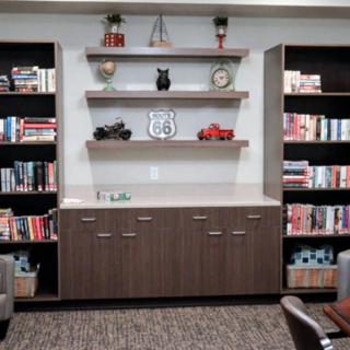 A cozy library corner with shelves filled with books and decorative items.