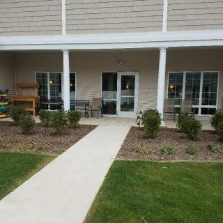 A well-maintained patio with a walkway and garden area in front of a building.