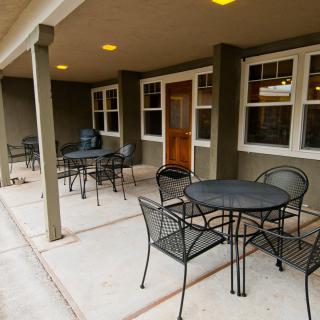 A covered patio area with several tables and chairs arranged for seating.