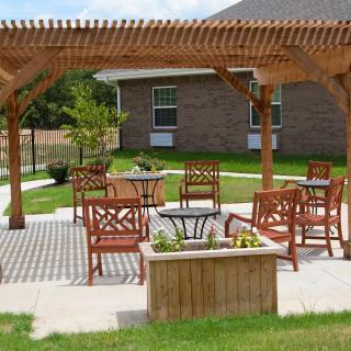 An outdoor patio area with a wooden pergola and seating.