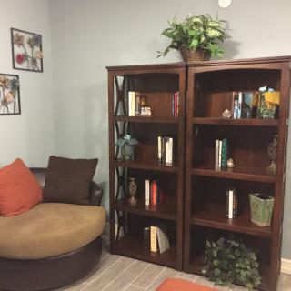 A cozy living room corner featuring a bookshelf and a comfortable chair.