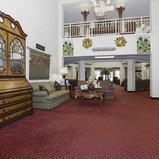 A spacious hotel lobby with elegant furnishings and a red carpet.
