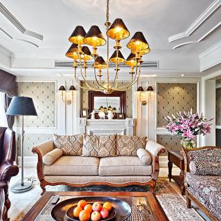 A luxurious living room featuring elegant interior design with a central chandelier, classic sofa, and decorative elements.