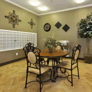 A cozy interior space with a round table and four chairs, adorned with decorative wall art and a potted plant.