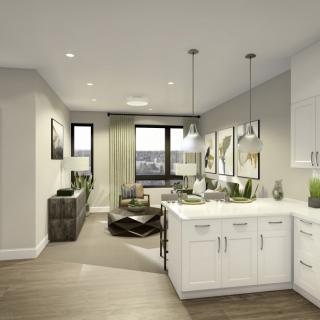 Modern open-concept kitchen and living room with white cabinetry and pendant lighting.