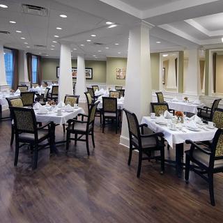 An elegant restaurant dining room set with tables and chairs.