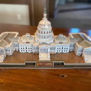 A miniature model of a capitol building displayed on a table.