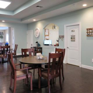 A cozy dining area with neatly arranged tables and chairs, featuring soft lighting and tasteful decor.