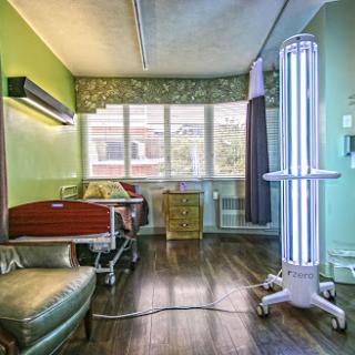 A modern hospital patient room equipped with UV light for sanitation and featuring bright green walls.