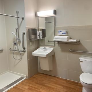 A modern and accessible bathroom featuring a shower, sink, and toilet.