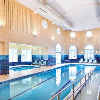 A serene indoor swimming pool area featuring elegant architecture and vibrant blue accents.