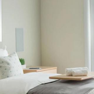 A minimalist bedroom with a cozy bed, soft lighting, and modern decor.