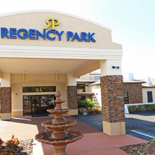 Entrance of Regency Park hotel with a fountain in front.