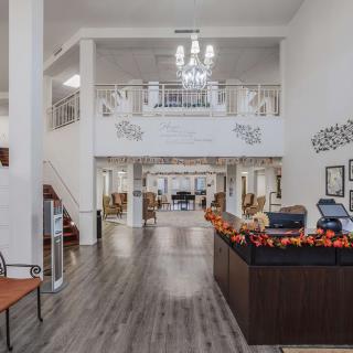 A spacious and modern lobby with a chandelier and decorated reception desk.