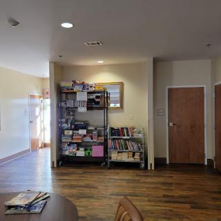 A cozy interior space featuring shelves filled with books and a wooden floor.