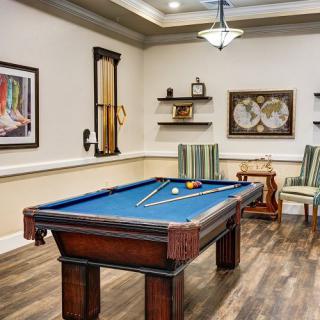 A stylish billiard room featuring a pool table and elegant furnishings.