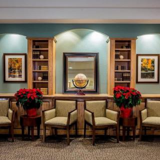 A neatly arranged waiting room featuring chairs, poinsettias, and wall decor.