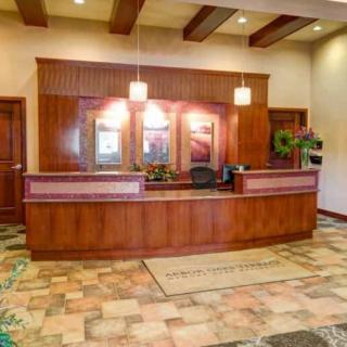 A welcoming hotel reception area with a wooden desk and warm lighting.